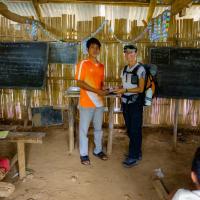 Day 3 trek - Moni giving books and pens to the school